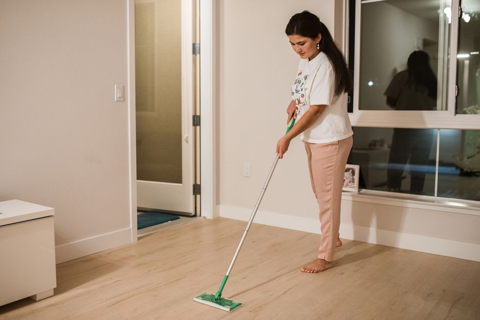 Mopping a hardwood floor as part of a deep cleaning service